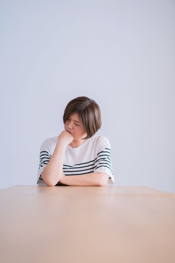 窓辺で考えごとをする女性